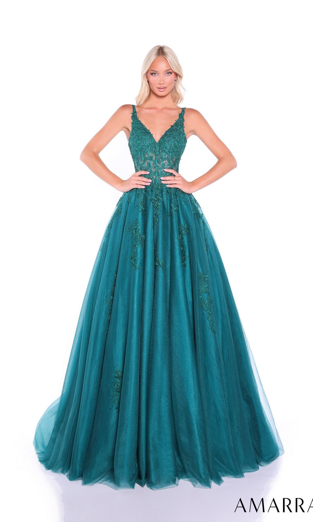 A woman poses against a white background in the Sheer-Waist Long A-Line Prom Dress, Amarra 89523—an emerald green, sleeveless, floor-length gown with lace embroidery.